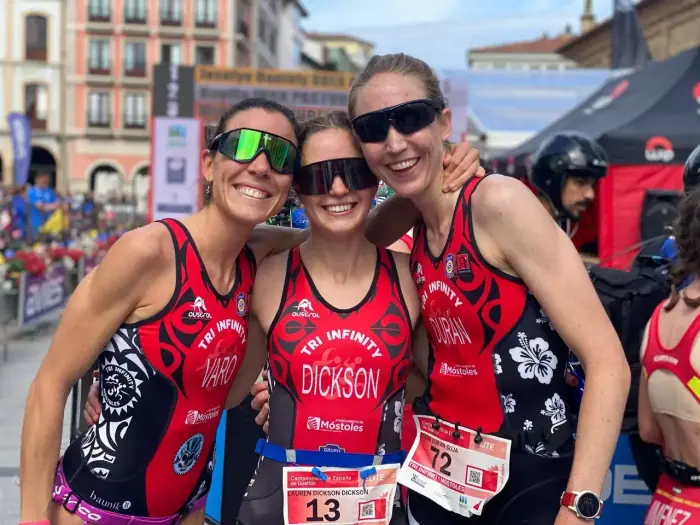 Triatletas adultas de Tri Infinity sonriendo tras una carrera